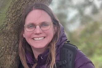 Sam Brown, a woman with glasses and long brown hair
